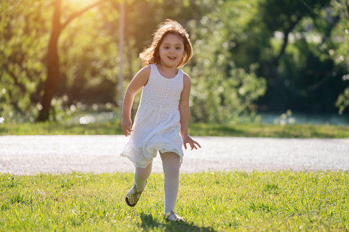Happy little girl running in nature