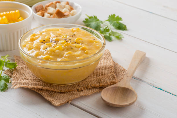 istock Corn soup in glass bowl and crispy bread with corn on white table. 944570974