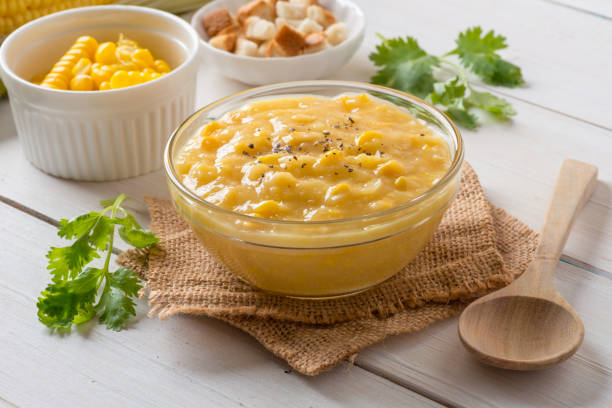 istock Corn soup in glass bowl and crispy bread with corn on white table. 944570984