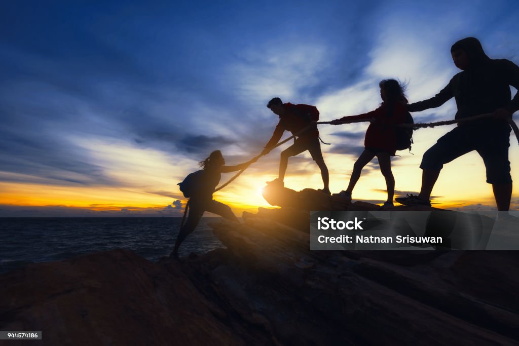 Climbing up on the mountain. Young asian people climbing up on the mountain,hiking and team work concept. Teamwork Stock Photo