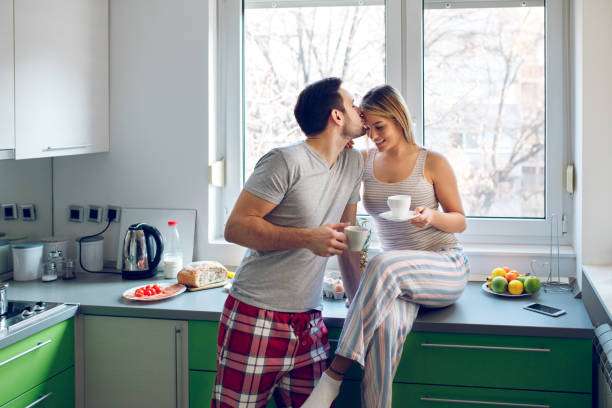 istock Romantic couple drinking coffee and flirting in the kitchen 944574320