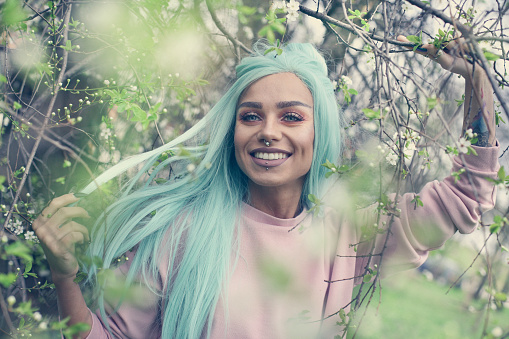 Smiling girl with mint hair in nature. Portrait.
