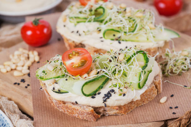istock Healthy vegetarian bruschettas with bread, micro greens, hummus, cherry tomatoes, cucumbers and pine nuts 944577448