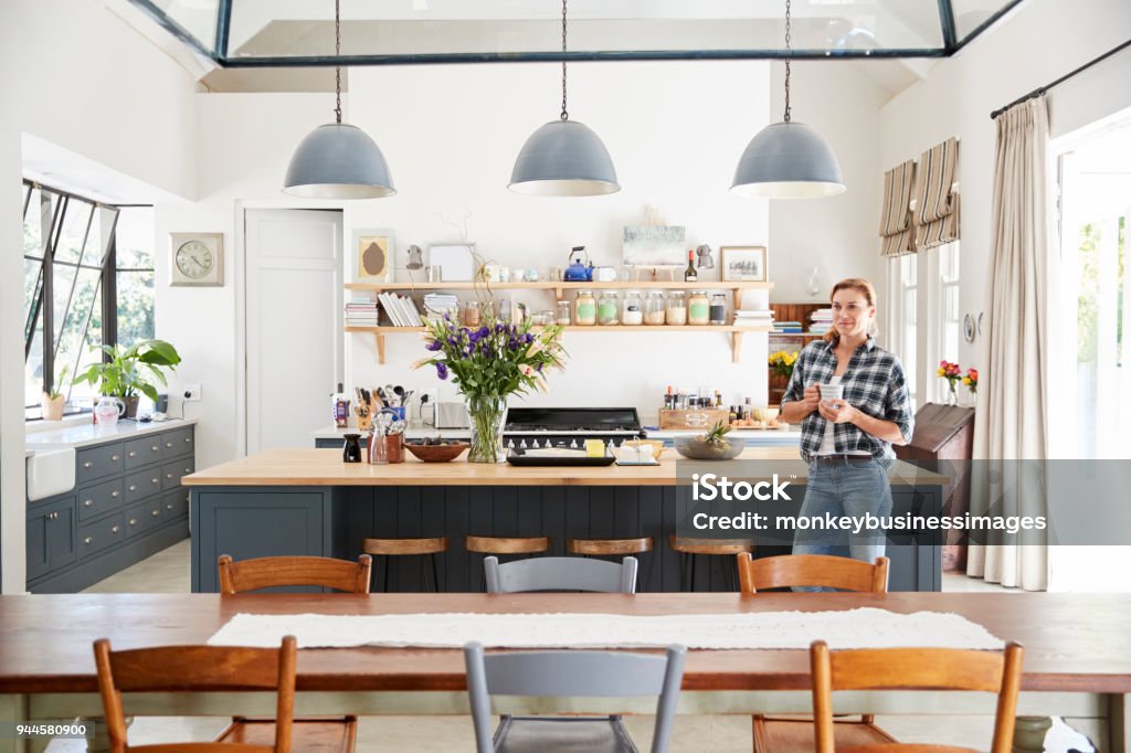 Young woman standing in an open plan kitchen dining room Kitchen Stock Photo