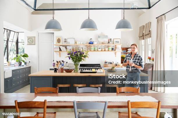 Young Woman Standing In An Open Plan Kitchen Dining Room Stock Photo - Download Image Now