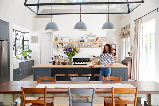 Mixed race woman leaning on kitchen island in open plan home