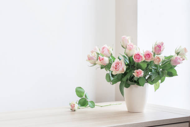 istock pink roses in vase on white background 944582054