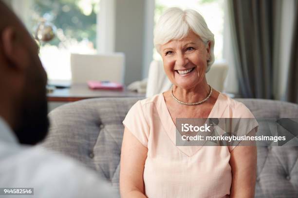 Happy Senior Woman Taking Financial Advice At Home Stock Photo - Download Image Now - Senior Adult, Listening, Psychotherapy