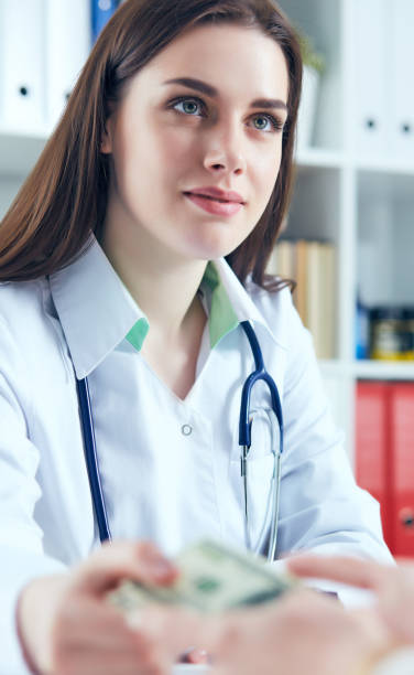 istock Young smiling Caucasian female doctor accepts bribes. 944582676