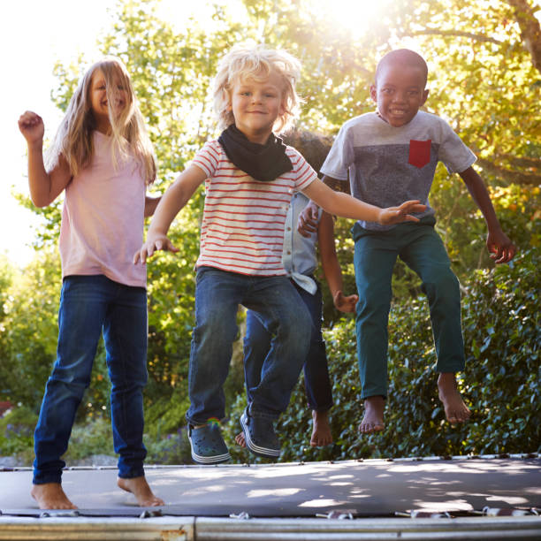 istock Four kids having fun together on a trampoline in the garden 944584938