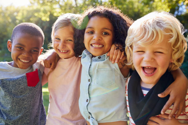 cuatro niños salir juntos en el jardín - happy child fotografías e imágenes de stock