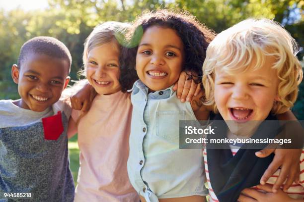 Foto de Quatro Crianças Saindo Juntos No Jardim e mais fotos de stock de Criança - Criança, Grupo Multiétnico, Sorrindo