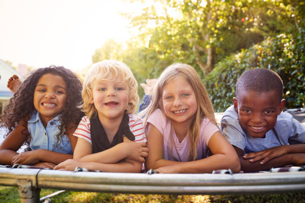 istock Four kids lying down together on a trampoline in the garden 944585224