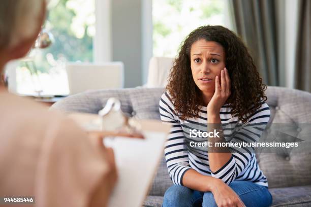 Photo libre de droit de Déprimé Jeune Femme Ayant De Thérapie Avec Une Psychologue banque d'images et plus d'images libres de droit de Femmes