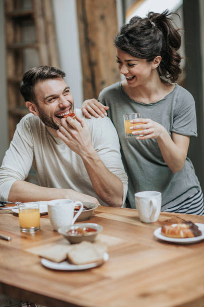 istock Happy couple enjoying while having breakfast together in dining room. 944585484