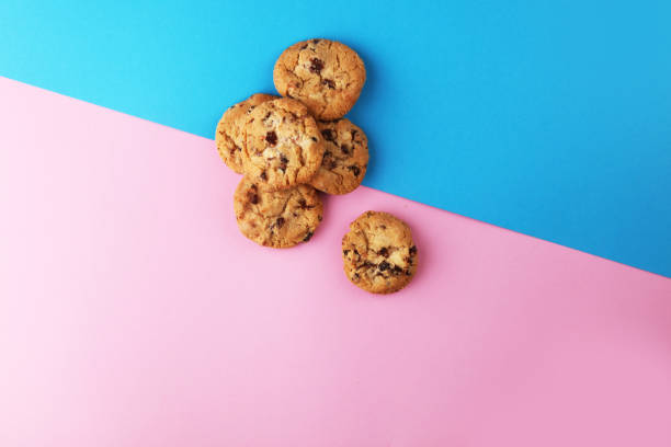 istock Chocolate cookies flat lay on colored paper. 944588214