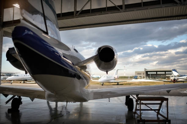 Aircraft in the hangar Private jet aircraft in the hangar open for regular maintenance service. airplane hangar photos stock pictures, royalty-free photos & images