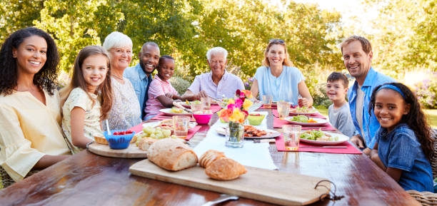 Friends and family having lunch in garden, looking to camera Friends and family having lunch in garden, looking to camera dining table photos stock pictures, royalty-free photos & images