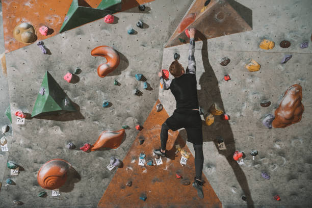 istock Man climbing wall with grips 944598128