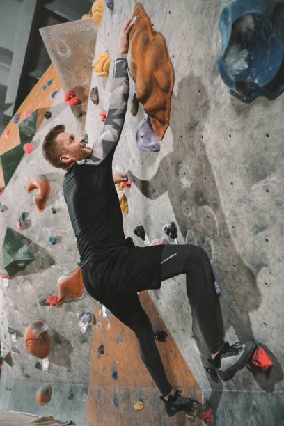 istock Man climbing wall with grips 944600632