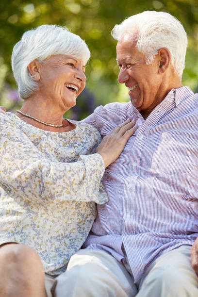 istock Happy senior couple sitting in garden looking at each other 944600708