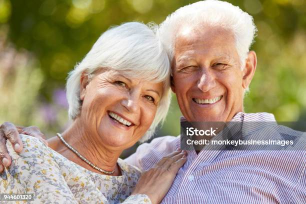 Feliz Pareja Senior Abrazando En Jardín Cabeza Y Hombros Foto de stock y más banco de imágenes de 60-69 años
