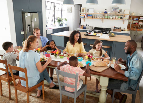 istock Two families having lunch together at home, elevated view 944606522
