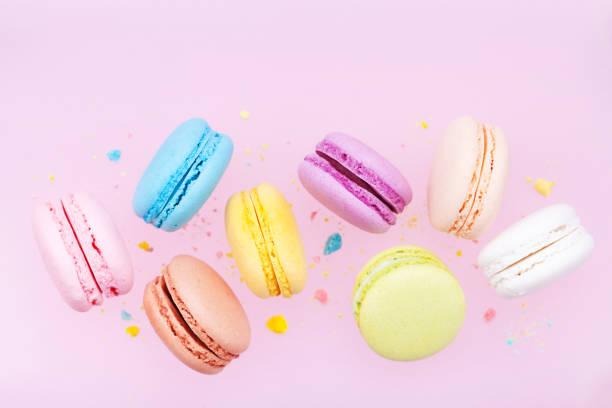 istock Flying colorful macaron or macaroon on pink pastel background. 944613242