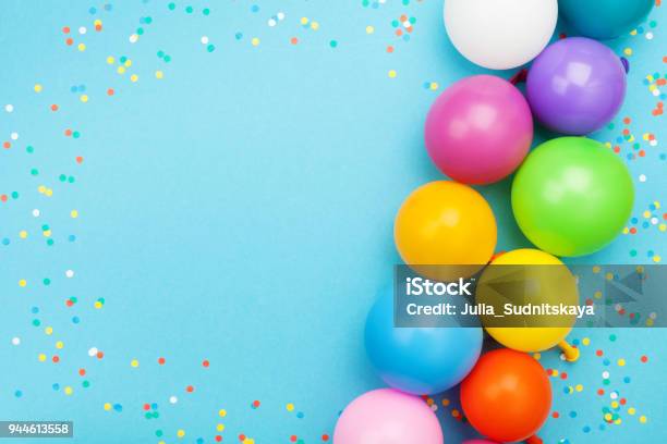 Confetti And Colorful Balloons For Birthday Party On Blue Table Top View Flat Lay Style Stock Photo - Download Image Now