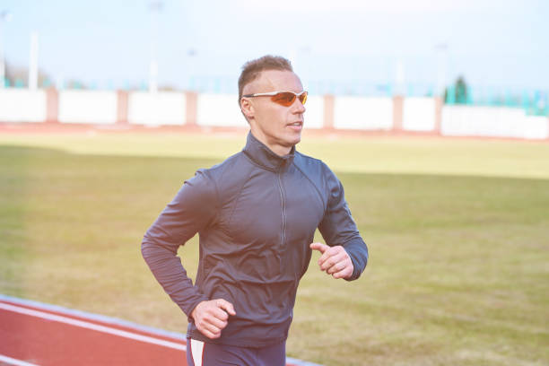 istock Handsome athletic man running on the treadmill stadium 944613938