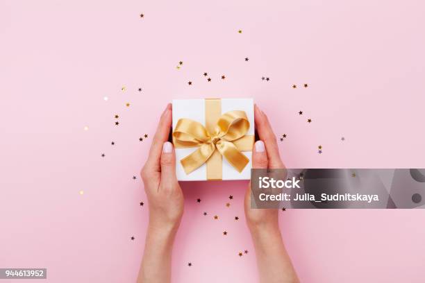 Womans Hands Holding Gift Or Present Box Decorated Confetti On Pink Pastel Table Top View Birthday Or Wedding Template Or Mockup Stock Photo - Download Image Now