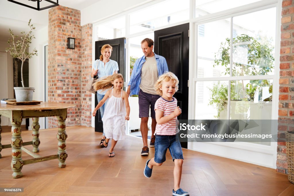 Young family arriving back to their home Family Stock Photo