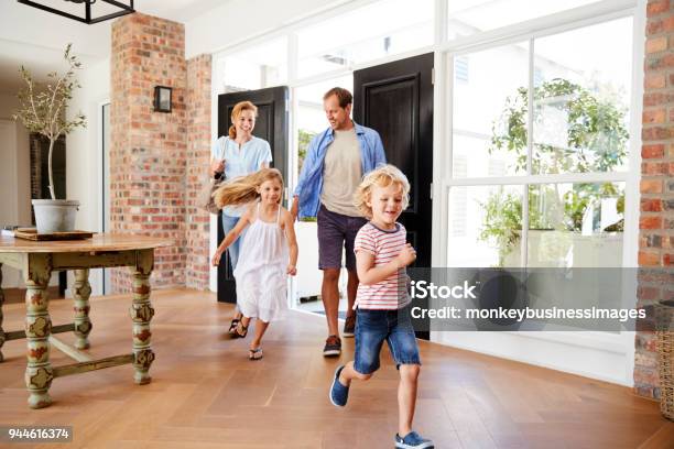 Young Family Arriving Back To Their Home Stock Photo - Download Image Now - Family, Domestic Life, Walking