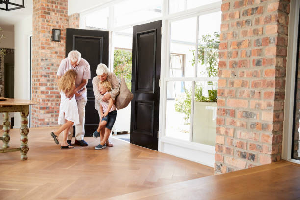istock Visiting grandparents hugging grandchildren as they arrive 944616388