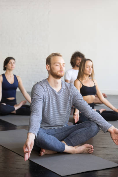 蓮のポーズでスポーティな若者のグループ - yoga class caucasian young adult group of people ストックフォトと画像