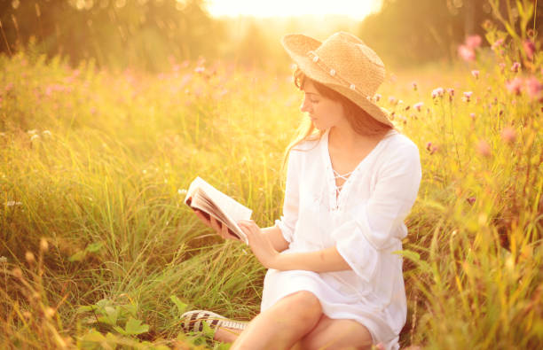 istock Beautiful young women on the nature with book 944622844