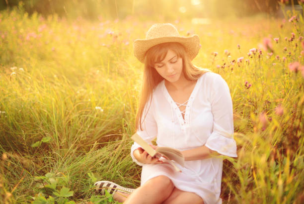 istock Beautiful young women on the nature with book 944623454