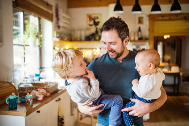 istock Father with two toddlers at home. 944623556