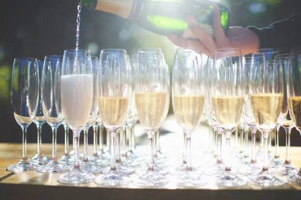 Photo of Pouring of champagne into glasses