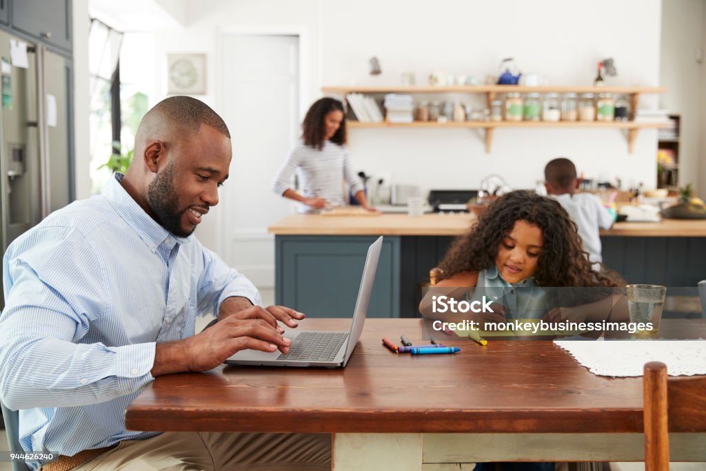 Young black family busy working in their kitchen Family Stock Photo
