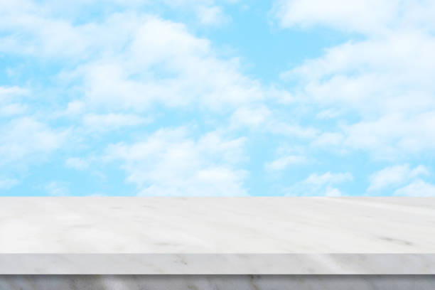 istock Empty white marble table over blue sky nature background, product display montage 944627444
