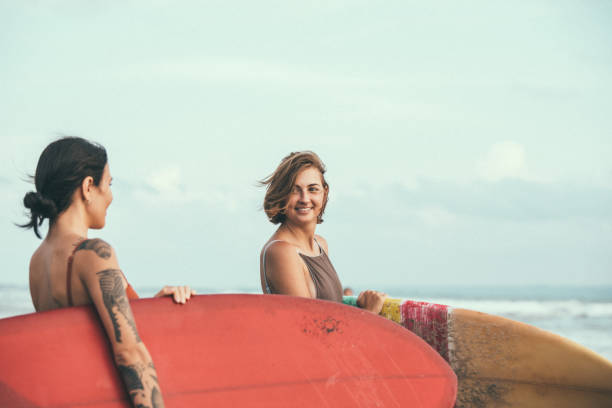 istock Beautiful young surfers at the beach 944627518