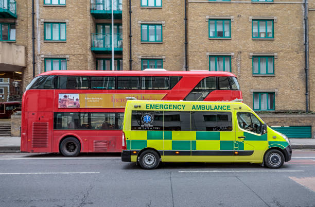 London, England - March 17, 2018: Typical modern dobbledecker bus and a ambulance in a street in London