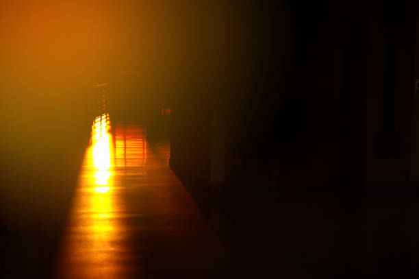 istock ray of orange sunlight reflection on the floor in dark black background 944627580