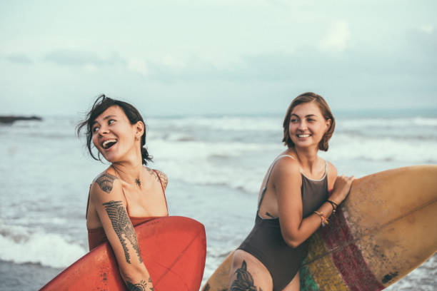 ビーチでかなりのサーファー - women sensuality surfing water sport ストックフォトと画像