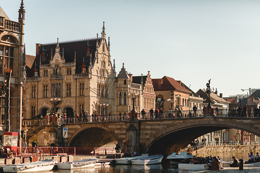 Ghent: people on ancient bridge above canal in Ghent, Belgium