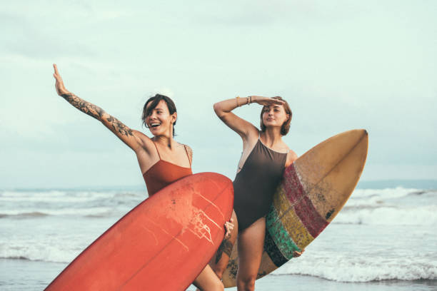 istock Pretty young surfers at the beach 944630308
