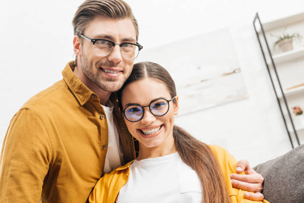 istock happy young couple embracing at home and looking at camera 944631486