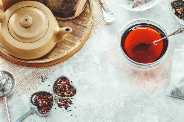 istock Ceramic tea pot, metal tea infuser and cup of black tea. Composition with tea accessories on a white background 944638358