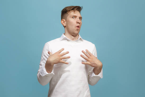 istock The young attractive man looking suprised isolated on blue 944642670